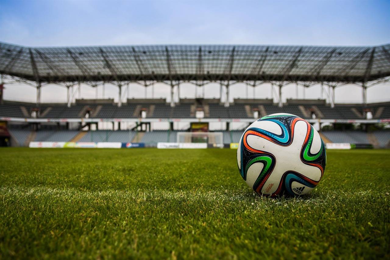 Bola sepak tergeletak di lapangan hijau