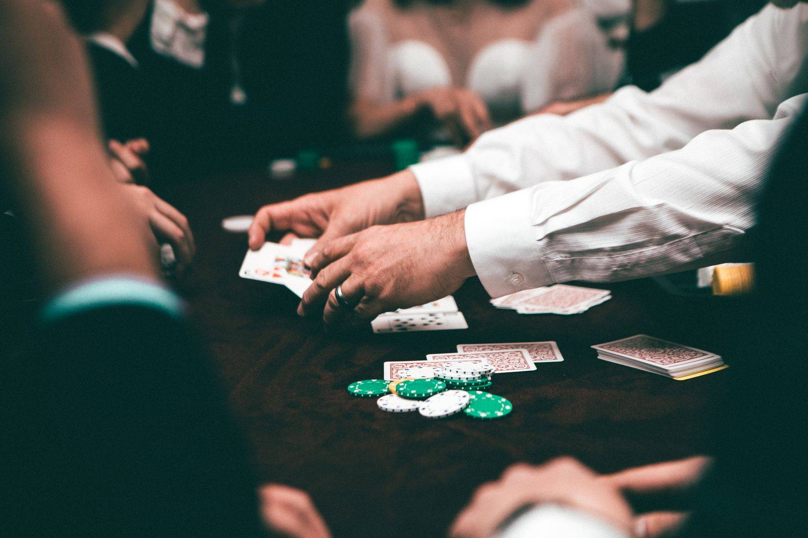 Meja permainan kartu dengan tangan dealer yang membagikan kartu